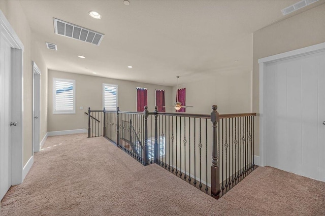 hallway with light colored carpet