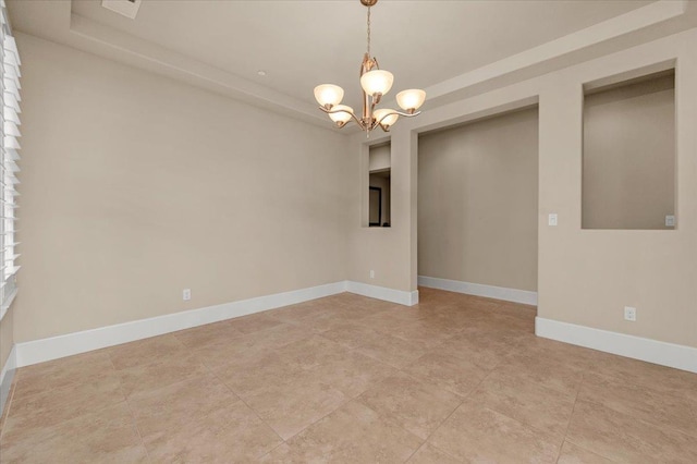 unfurnished room featuring a chandelier, light tile patterned floors, and a tray ceiling