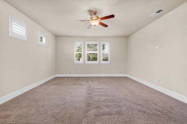 carpeted spare room featuring ceiling fan