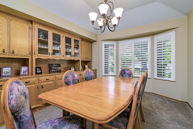 carpeted dining room featuring vaulted ceiling and a notable chandelier