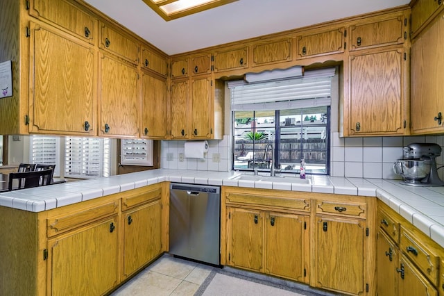 kitchen with sink, backsplash, tile countertops, and stainless steel dishwasher