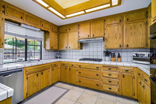 kitchen featuring sink, decorative backsplash, tile countertops, and stainless steel appliances