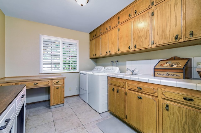 laundry room with separate washer and dryer, light tile patterned floors, and cabinets