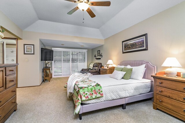 carpeted bedroom featuring a tray ceiling and ceiling fan