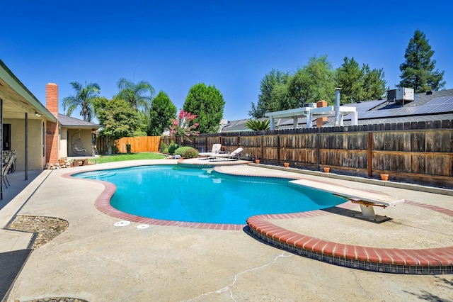 view of swimming pool with a patio and a diving board