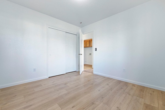 unfurnished bedroom with light hardwood / wood-style floors and a closet