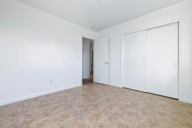 unfurnished bedroom with light tile patterned floors and a closet