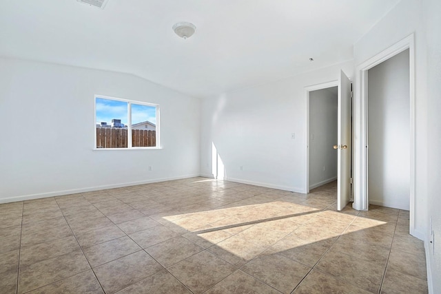 tiled empty room with lofted ceiling