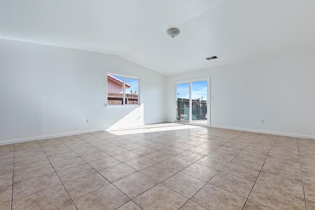 tiled empty room with lofted ceiling