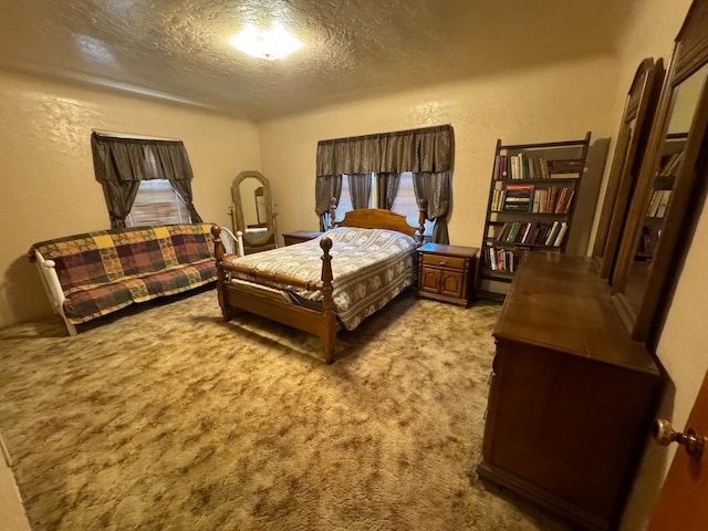 bedroom with a textured ceiling, a textured wall, and carpet floors