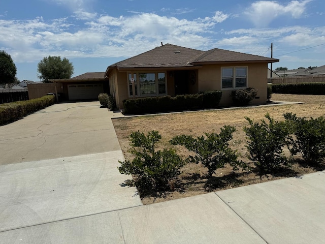 single story home with fence, a garage, driveway, and stucco siding