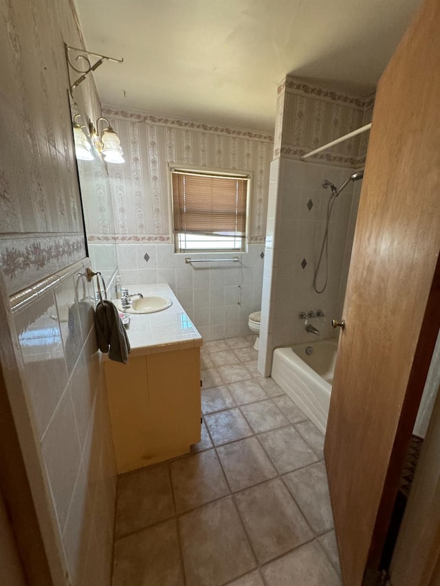 bathroom featuring vanity, wallpapered walls, wainscoting, tile walls, and toilet