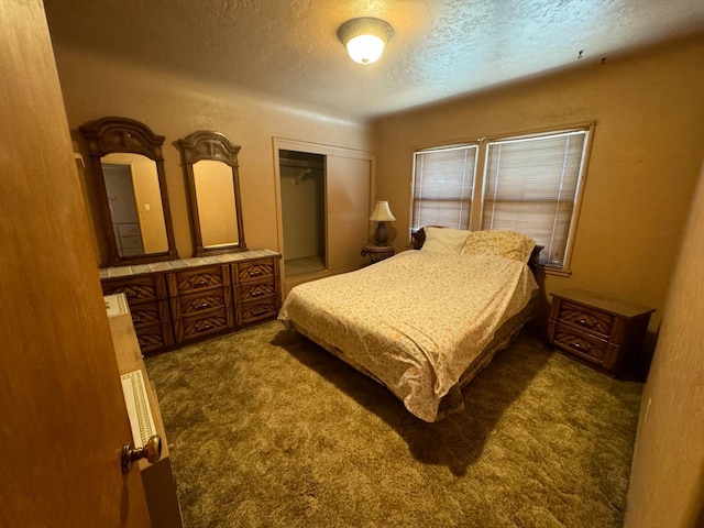 bedroom with a closet, a textured ceiling, and carpet floors