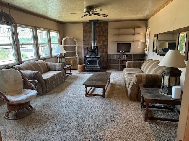 carpeted living area featuring a textured ceiling, ceiling fan, a wood stove, and crown molding