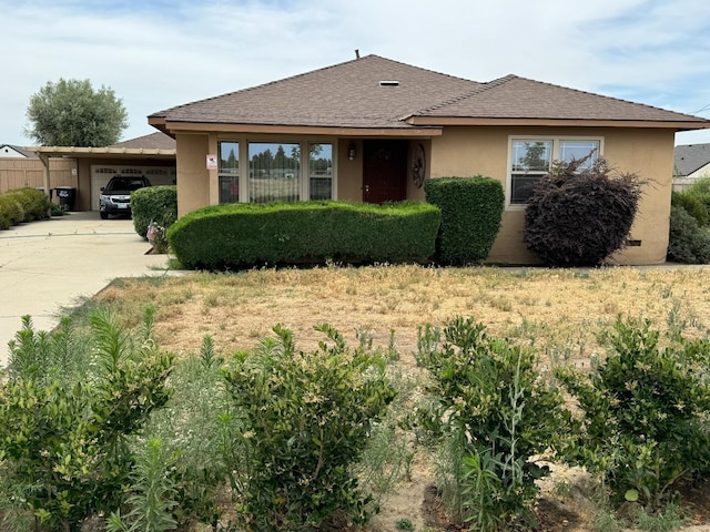 view of front of property featuring stucco siding, an attached garage, roof with shingles, and driveway