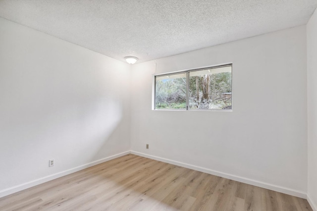 unfurnished room featuring a textured ceiling and light hardwood / wood-style flooring