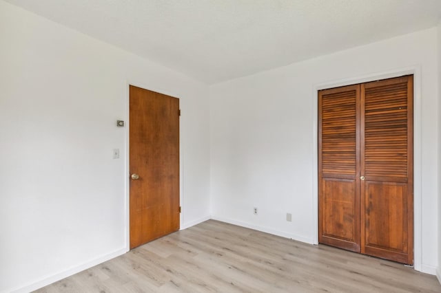 unfurnished bedroom featuring light hardwood / wood-style floors and a closet