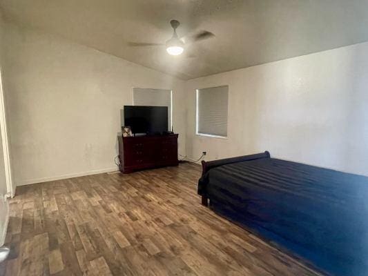 unfurnished bedroom featuring hardwood / wood-style flooring, ceiling fan, and lofted ceiling