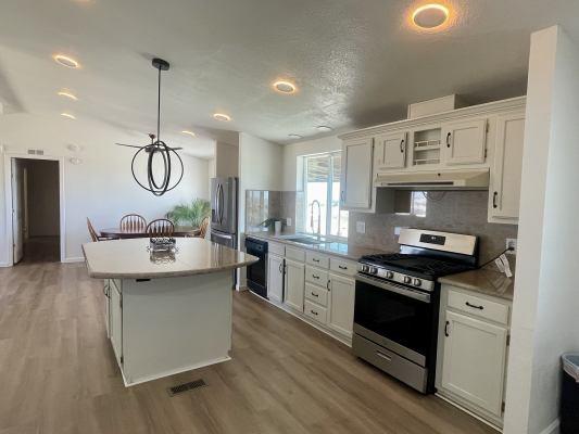 kitchen featuring white cabinetry, appliances with stainless steel finishes, a center island, and sink