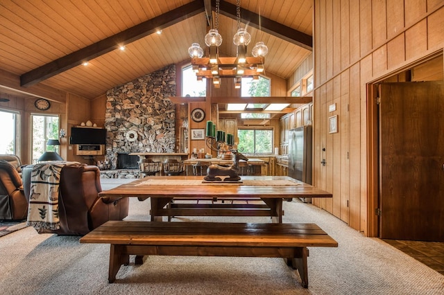 dining space with plenty of natural light, wooden walls, and carpet