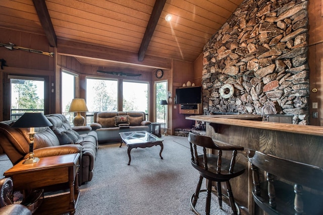 carpeted living room with vaulted ceiling with beams, wooden ceiling, and wood walls