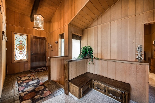 foyer with wood ceiling, wood walls, and dark colored carpet