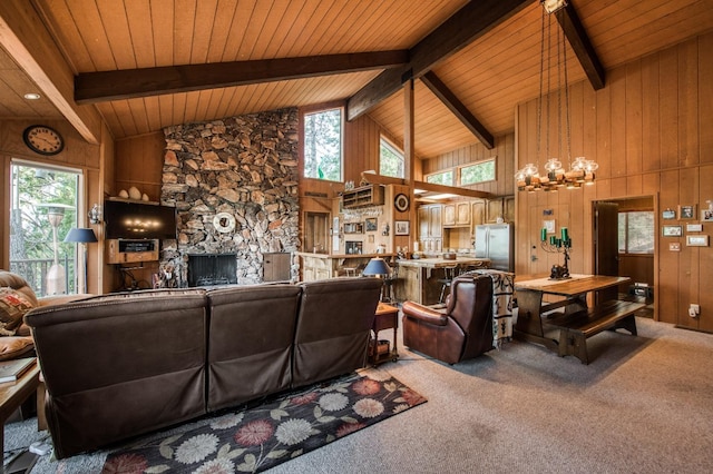 living room with beamed ceiling, high vaulted ceiling, wooden walls, and carpet floors