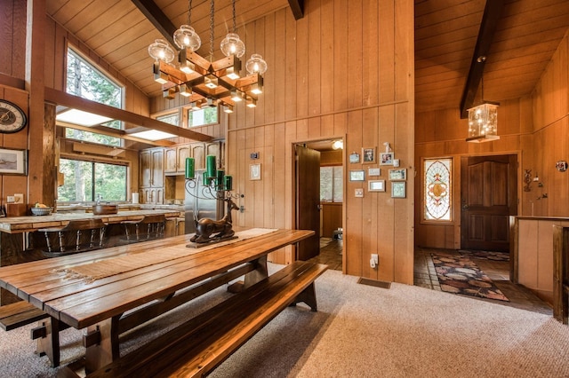 dining area with wood ceiling, beam ceiling, high vaulted ceiling, and dark colored carpet