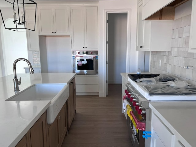 kitchen featuring hardwood / wood-style flooring, stainless steel appliances, and white cabinetry