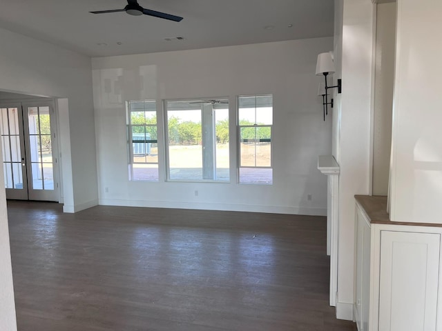 unfurnished living room with dark hardwood / wood-style flooring, ceiling fan, and plenty of natural light