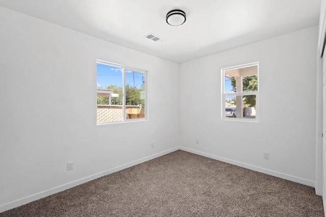 carpeted spare room featuring plenty of natural light