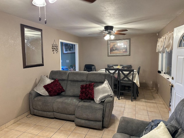 living room featuring light tile patterned floors, a textured ceiling, and ceiling fan