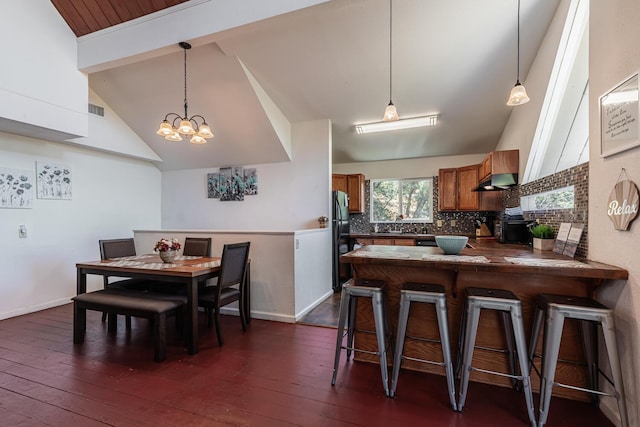 dining space with dark wood-type flooring, visible vents, high vaulted ceiling, and baseboards