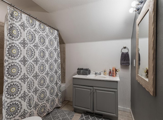 full bath with toilet, vanity, vaulted ceiling, and tile patterned floors