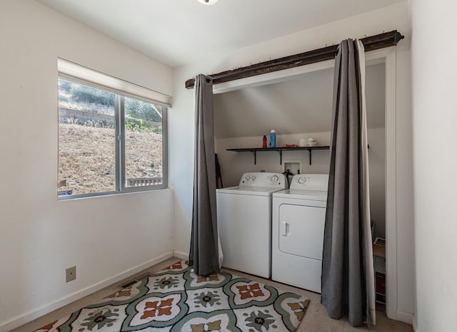 clothes washing area with laundry area, washing machine and dryer, and baseboards