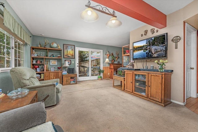 carpeted living room featuring beam ceiling and plenty of natural light