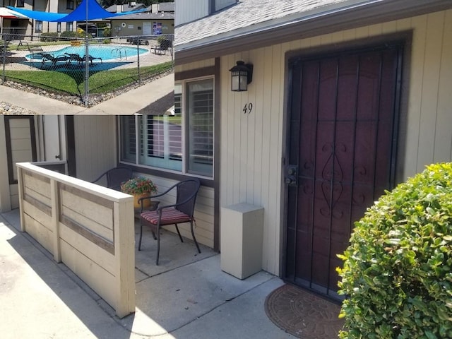 view of exterior entry with a patio and a fenced in pool