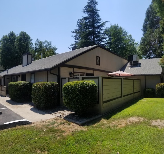 view of property exterior featuring a lawn and central AC unit