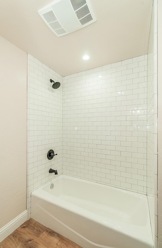 bathroom with tiled shower / bath combo and wood-type flooring