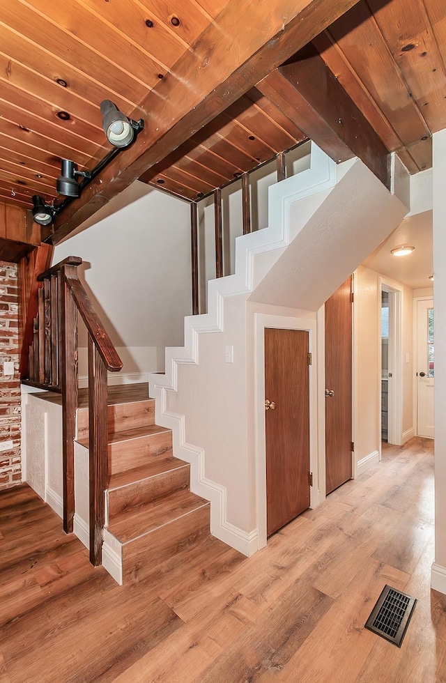 staircase featuring wood-type flooring and wood ceiling