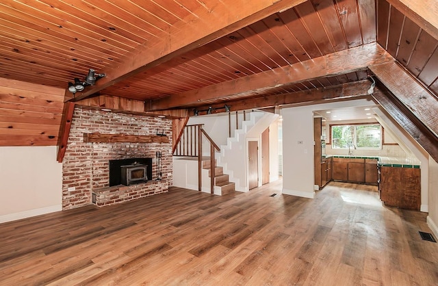 unfurnished living room featuring wood ceiling, hardwood / wood-style floors, and beam ceiling