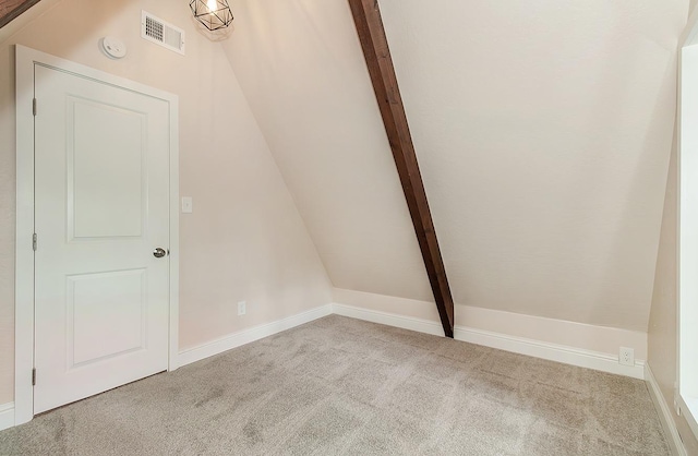 bonus room with vaulted ceiling with beams and light colored carpet