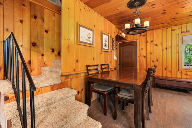 dining room featuring a baseboard radiator, dark wood-type flooring, wooden walls, and wood ceiling