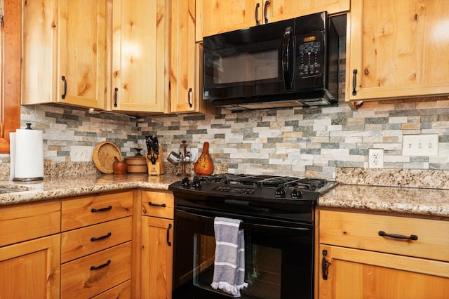 kitchen with light stone countertops, backsplash, and black appliances