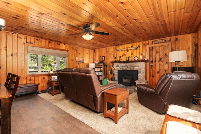 living room featuring ceiling fan, hardwood / wood-style floors, wooden walls, a fireplace, and wooden ceiling