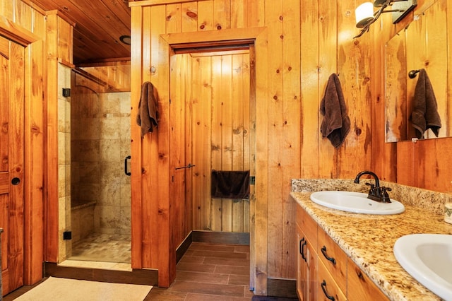 bathroom with vanity, wooden walls, and a shower with shower door