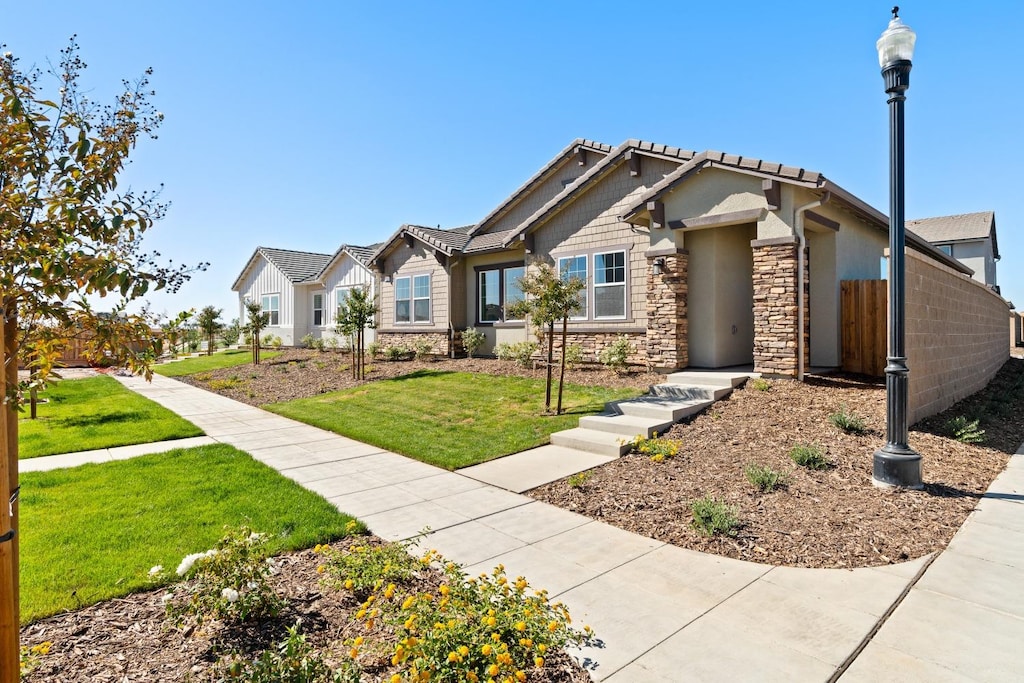 craftsman inspired home featuring a front lawn