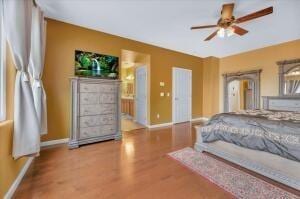 bedroom with ceiling fan, light hardwood / wood-style floors, and ensuite bathroom