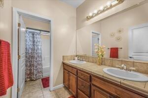 bathroom featuring tile patterned flooring, vanity, and shower / bathtub combination with curtain