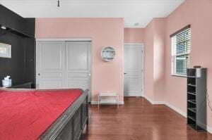 bedroom with a closet and dark wood-type flooring